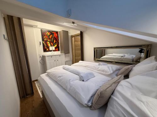 a bedroom with three beds and a mirror at Alpinoase City Centre Zell am See in Zell am See