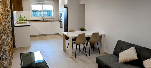 a living room and kitchen with a table and chairs at Casa de poble Cal Casellas in San Martín Sasgayolas