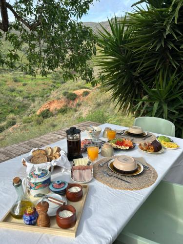 una mesa blanca con comida y bebidas. en Casa rural La Bodega, en Castell de Ferro