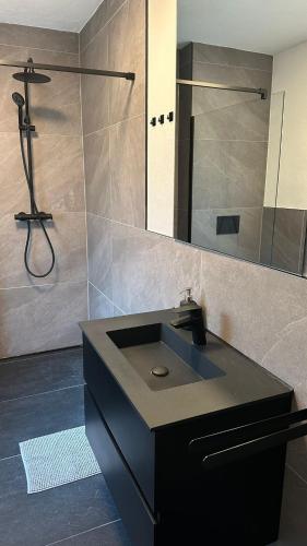 un bagno con un lavandino nero e una doccia di Casa Verona a Landstuhl