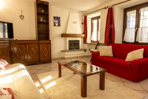 een woonkamer met een rode bank en een salontafel bij Maison Plan de Dieu in Saint-Pierre