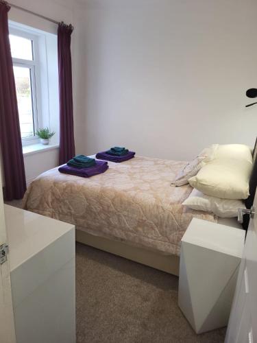 a bedroom with a bed with two towels on it at 4 johns terrace in Carmel