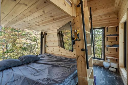 una camera da letto in una casetta con un letto di Kings River Micro Cabin a Eureka Springs