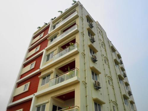 THS Suites - Luxurious 2 BHK AC apartments with Tirumala Views - Near Marriott, Taj and ITC 5 star hotels - Walkable to PS4, A2B, Orion, Starbucks cafes - Close to Thiruchanur and Alipiri flyover في تيروباتي: مبنى طويل وبه شرفات على جانبه