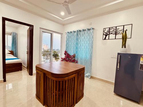 THS Suites - Luxurious 2 BHK AC apartments with Tirumala Views - Near Marriott, Taj and ITC 5 star hotels - Walkable to PS4, A2B, Orion, Starbucks cafes - Close to Thiruchanur and Alipiri flyover في تيروباتي: غرفة معيشة مع ثلاجة وسرير