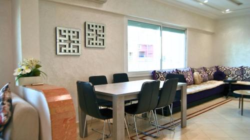 a living room with a table and a couch at 2 BR apartment - City Center Residency - Panoramic City Views - 3 Min Train Access by ZenStay in Fès