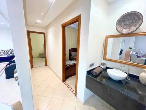 a bathroom with a sink and a mirror at 2 BR apartment - City Center Residency - Panoramic City Views - 3 Min Train Access by ZenStay in Fès