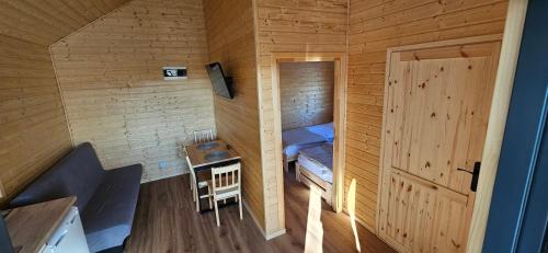 a small room with a bed in a wooden cabin at Perłowy Port in Gąski