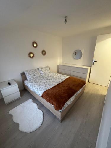 Un dormitorio con una cama grande y una alfombra blanca. en Maison cocooning, en Saint-Sébastien-sur-Loire