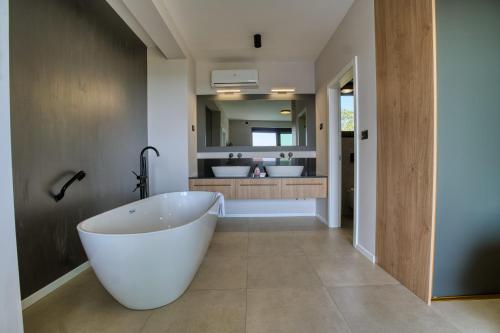 een badkamer met een groot wit bad op de voorgrond bij Villa Bella in Bale