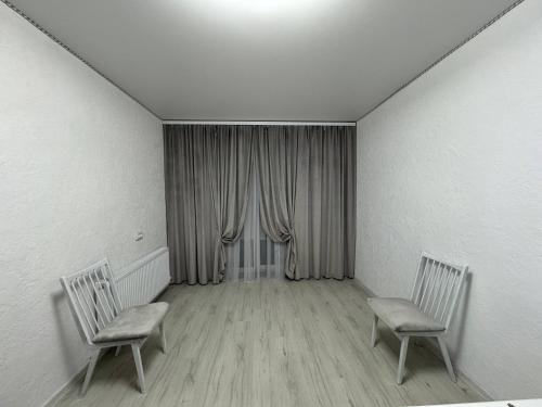 two chairs in an empty room with a window at Apartament cu 1 camera in Soroca
