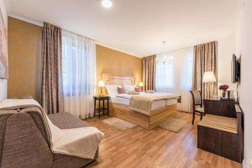 a hotel room with two beds and a couch at Plitvice Falls Cottage - Luxury rooms & Dinner in Plitvica Selo
