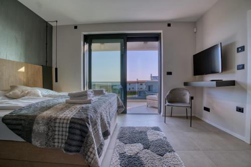 een slaapkamer met een bed en een glazen schuifdeur bij Villa Bella in Bale