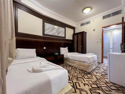 a hotel room with two beds and a mirror at فندق مهوى الفؤاد - المعابدة in An Naqāʼ