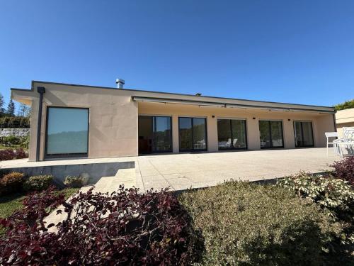 a house with glass windows and a patio at Quinta de Sub-Ribas, ideal para famílias in Vizela