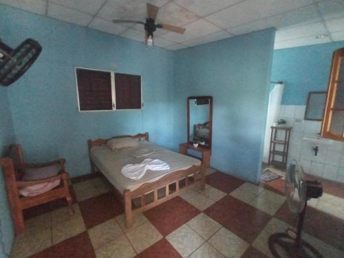 Un dormitorio con una cama y un ventilador de techo. en hostal Casa pura vida, en Rivas