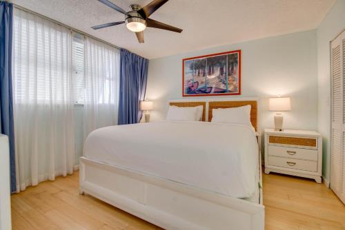 ein Schlafzimmer mit einem weißen Bett und einem Deckenventilator in der Unterkunft The Cayo Coco | Key West Condo with Pool Hot Tub & Balcony Views in Key West