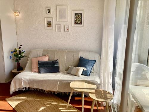 a small room with a couch with pillows on it at Idyllique ! Terrasse vue jardin et montagne, parking, local à vélos, à 2 pas de la plage et piscine de mai à septembre ! in Argelès-sur-Mer