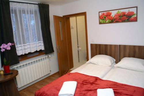 a bedroom with a bed with a red blanket at Willa Anna Maria in Białka Tatrzanska