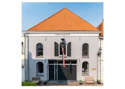 a white building with an orange roof at Appartement B&B In de Gulde Steur in Deventer