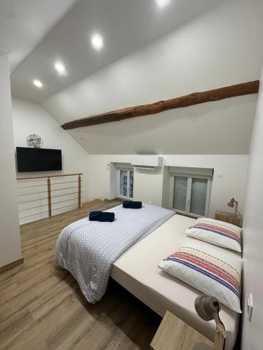 een slaapkamer met twee bedden en een flatscreen-tv bij Maison le petit coin secret in Châtillon-sur-Seine