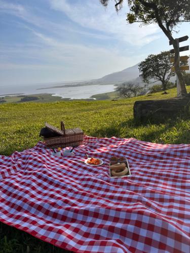 a picnic blanket on the grass in a field at Chalé Bela Vista - Três Cachoeiras in Três Cachoeiras