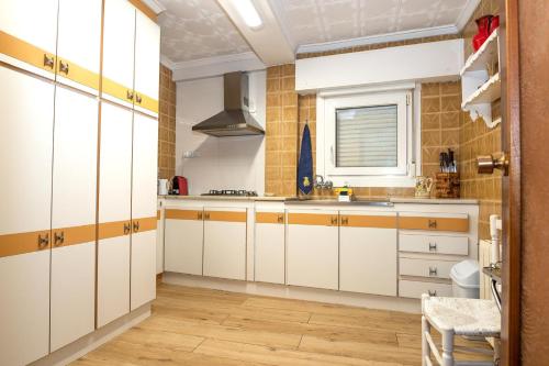 una cucina con mobili bianchi e una finestra di CASA TONIO a Banyeres de Mariola