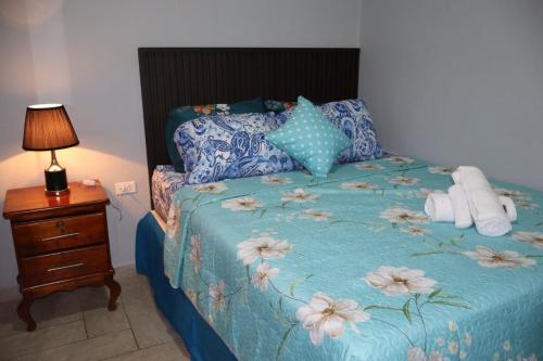a bedroom with a bed with a blue comforter and pillows at Costabay in El Zapote