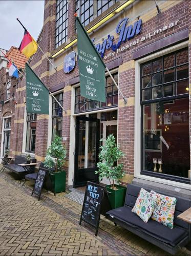 a store with a bench in front of a building at Kings Inn City Hostel in Alkmaar