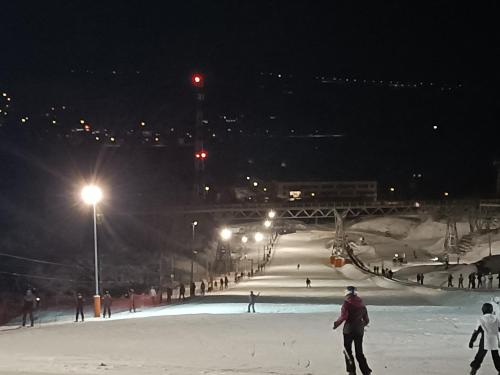 a group of people skiing in the snow at night at Noclegi w Dolinie Drwęcy in Kurzętnik