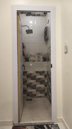 a glass door leading to a shower in a room at Aswan Key Cozy in Nag` el-Ramla