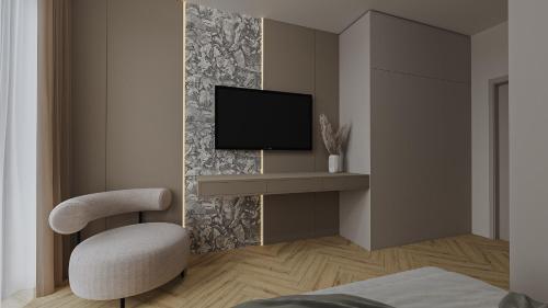 a room with a chair and a tv on a wall at Aqua & Wellness resort Alzbeta in Liptovský Mikuláš