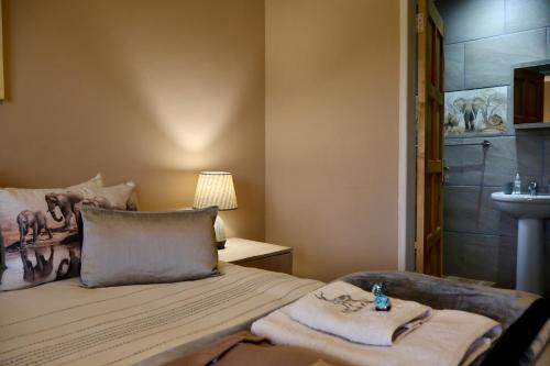 a bedroom with a bed with towels on it at Uitvlugt Ponds in Dullstroom