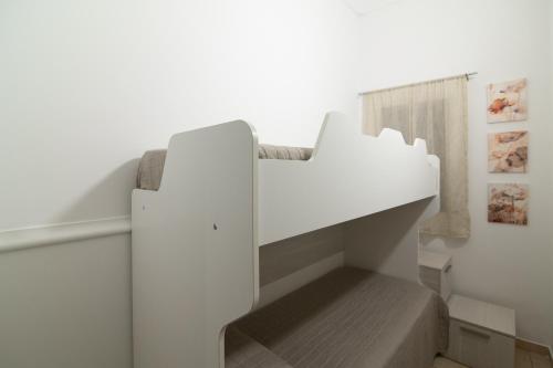 a white staircase in a room with a bed at Dimora Saracena in Adrano