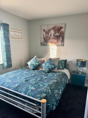 a bedroom with a bed with a blue comforter at Willow Cottage in North Muskham