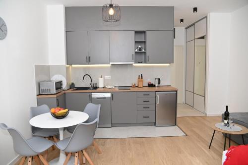 a kitchen with a white table and chairs and a table and a table and chairs at Apartman Perfect in Trebinje