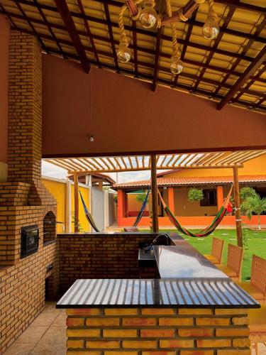 een patio met een picknicktafel en een bakstenen muur bij Casa Beberibe in Beberibe