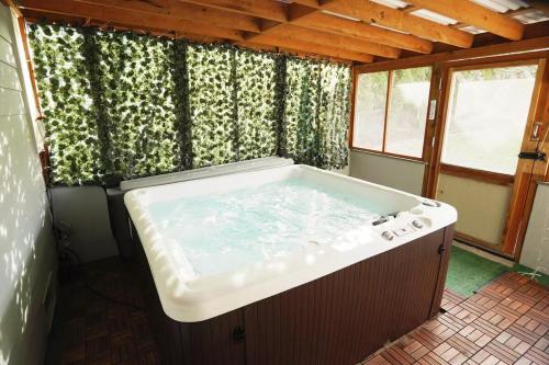 a large bath tub in a room with windows at Charming beach home with Ocean & Mt. Baker View in Camano