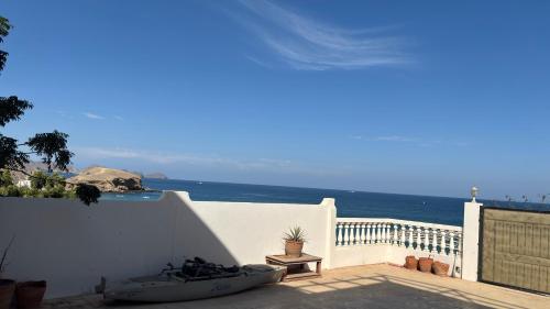 a boat sitting on a patio near the ocean at Qantab village apartment in Muscat