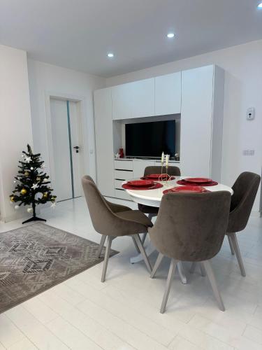 a dining room with a table and a christmas tree at Studio Vivo Residence in Baia Mare