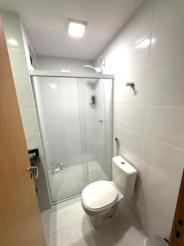 a white bathroom with a shower and a toilet at Apê moderno no Centro, perto de tudo em Belém in Belém