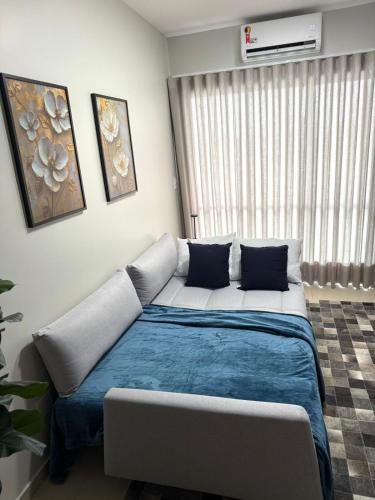 a bedroom with a large bed with a blue blanket at Apê moderno no Centro, perto de tudo em Belém in Belém