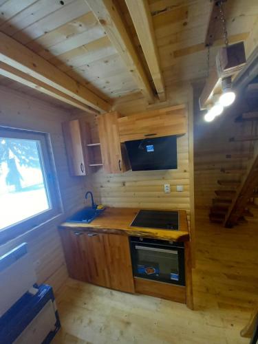 a kitchen in a tiny house with a sink at Planinska Vikendica SP Jahorina in Bistrica