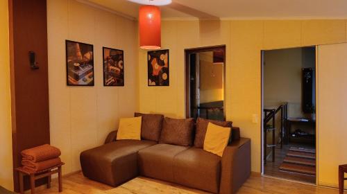 a living room with a brown couch in a room at Zaļais namiņš in Ventspils
