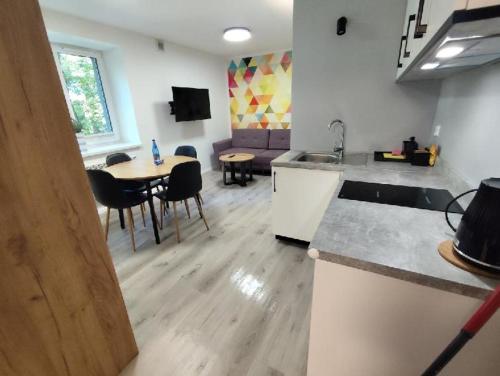 a kitchen and living room with a table and chairs at Apartamenty Dąbrówka Cieplice Zdrój 1,15 in Jelenia Góra