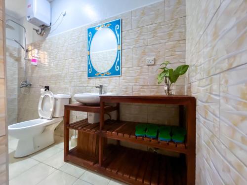 a bathroom with a sink and a toilet and a mirror at Keisha Luxury Furnished Apartment Bukoto in Kampala