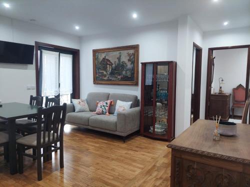 a living room with a couch and a table at Casa Mucha - Rés do Chão e Andar in Arco de Baúlhe