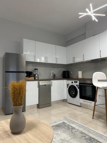 una cucina con armadi bianchi e un vaso di Central stay a Larisa