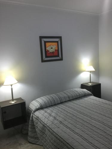 1 dormitorio con 1 cama y 2 mesas con lámparas en Apartamento Los Abuelos Calle Peron en Colón