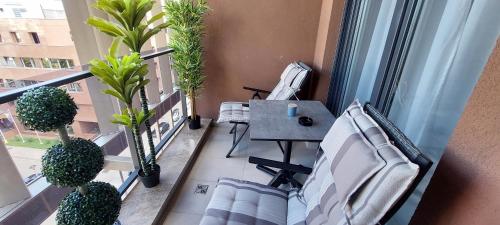 a balcony with a table and chairs and plants at Extra Apartman Palata in Banja Luka